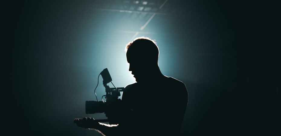 silhouette of man standing in front of microphone